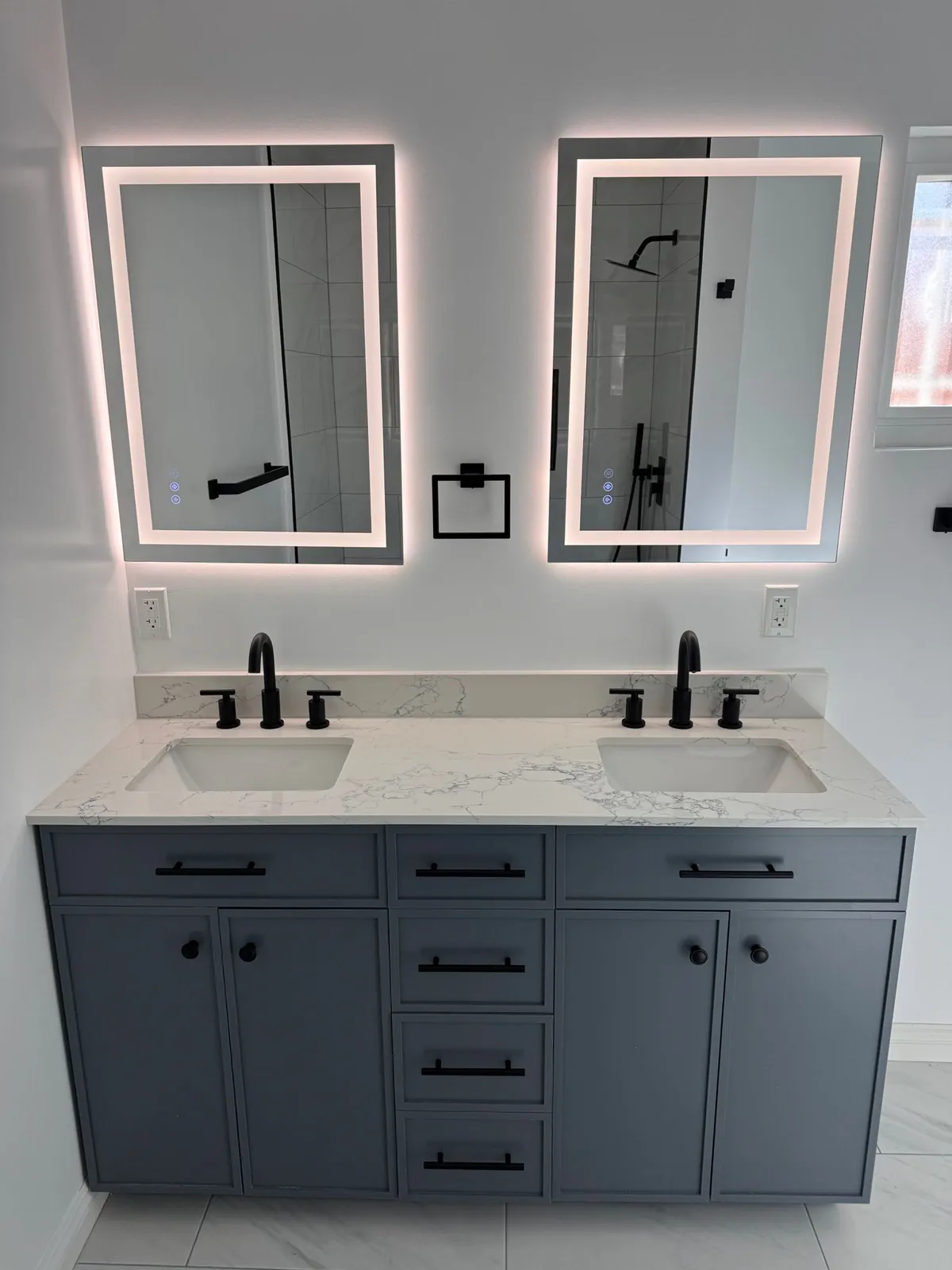 Double vanity with LED mirrors and matte black fixtures