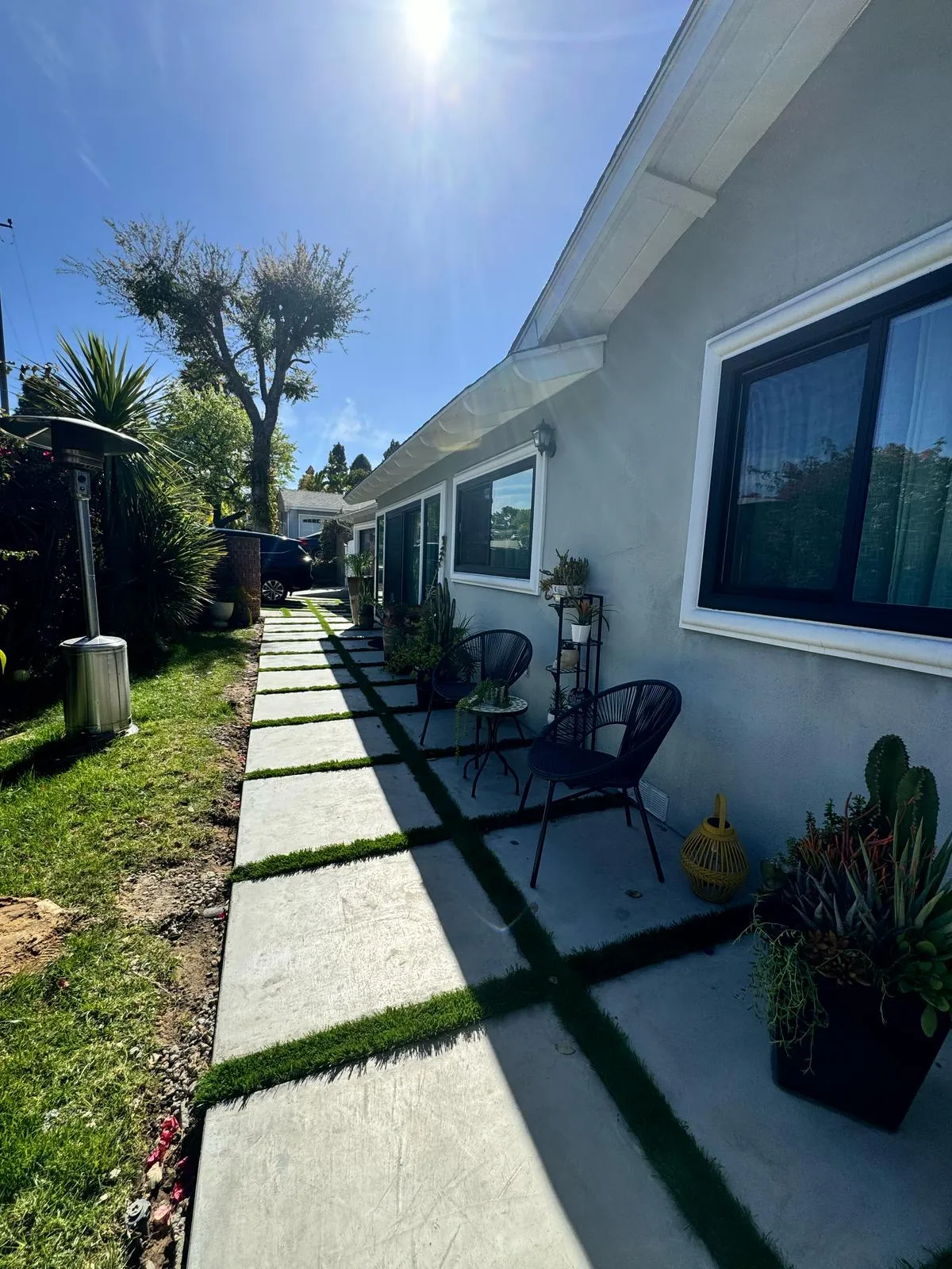 Paver walkway with seating and planted border along the house