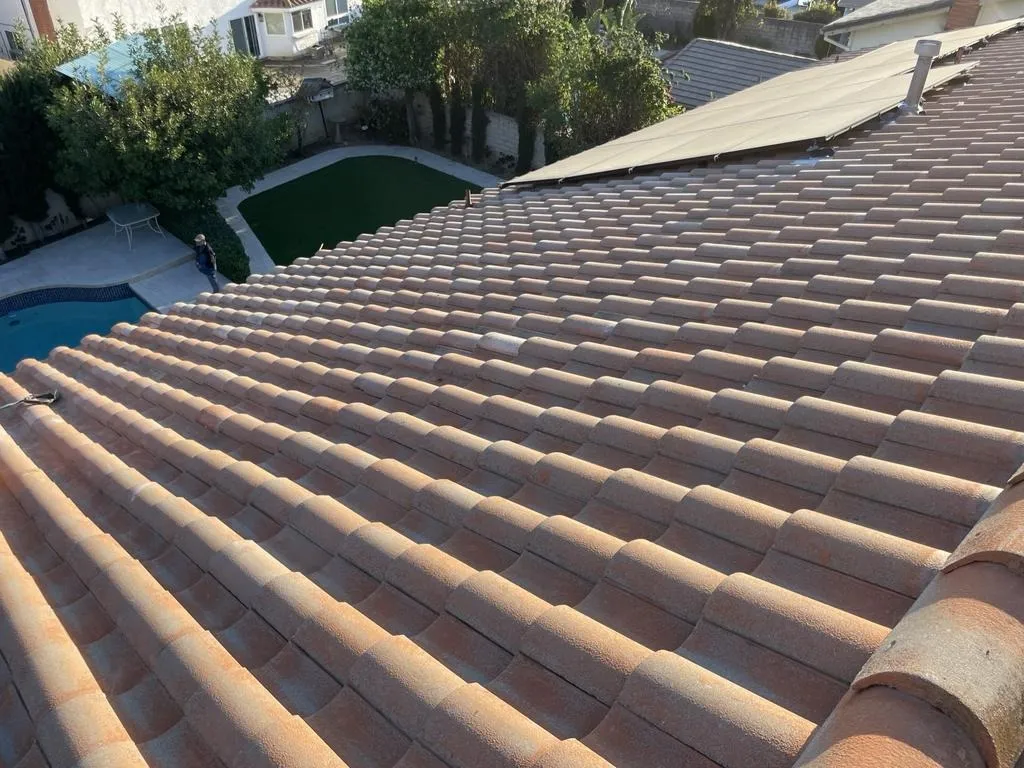 New clay tile roof above a backyard pool on a hillside home
