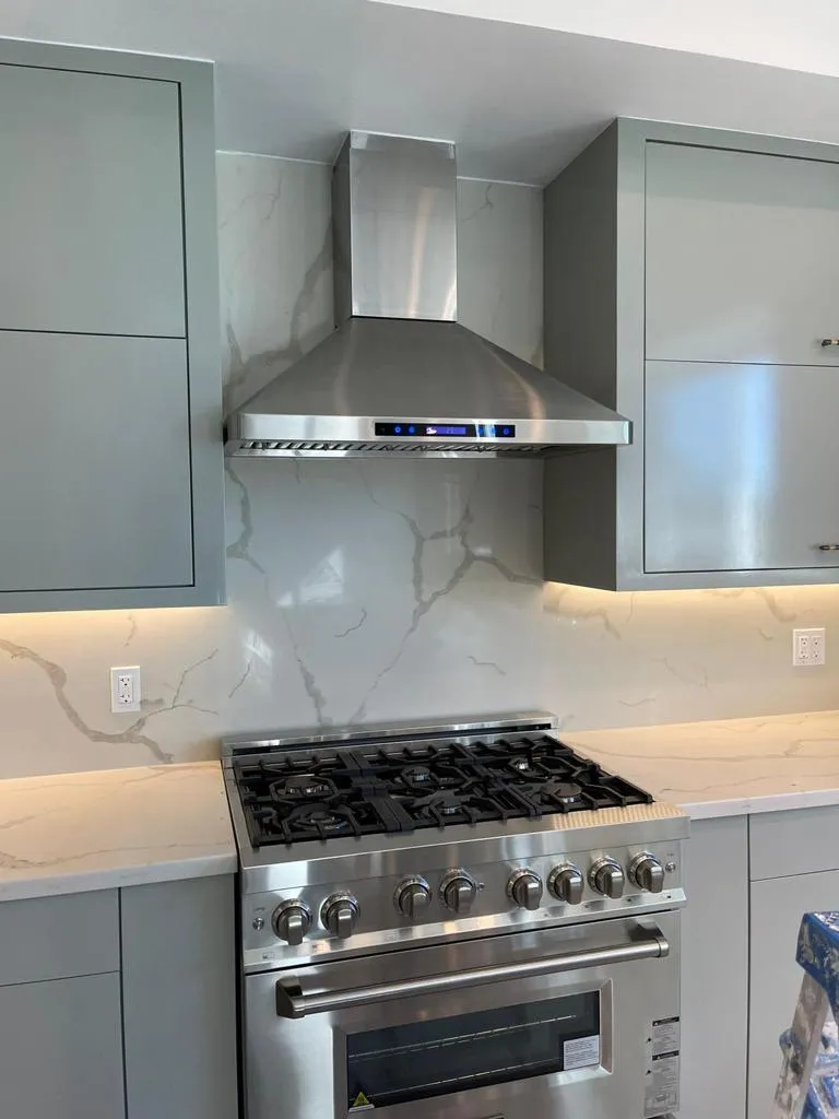 Professional range with marble backsplash and stainless hood