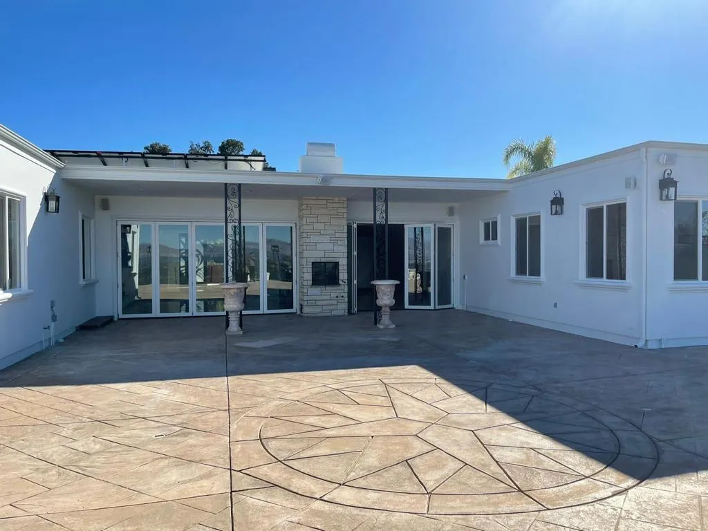 Rear elevation with fresh white stucco and stamped concrete patio