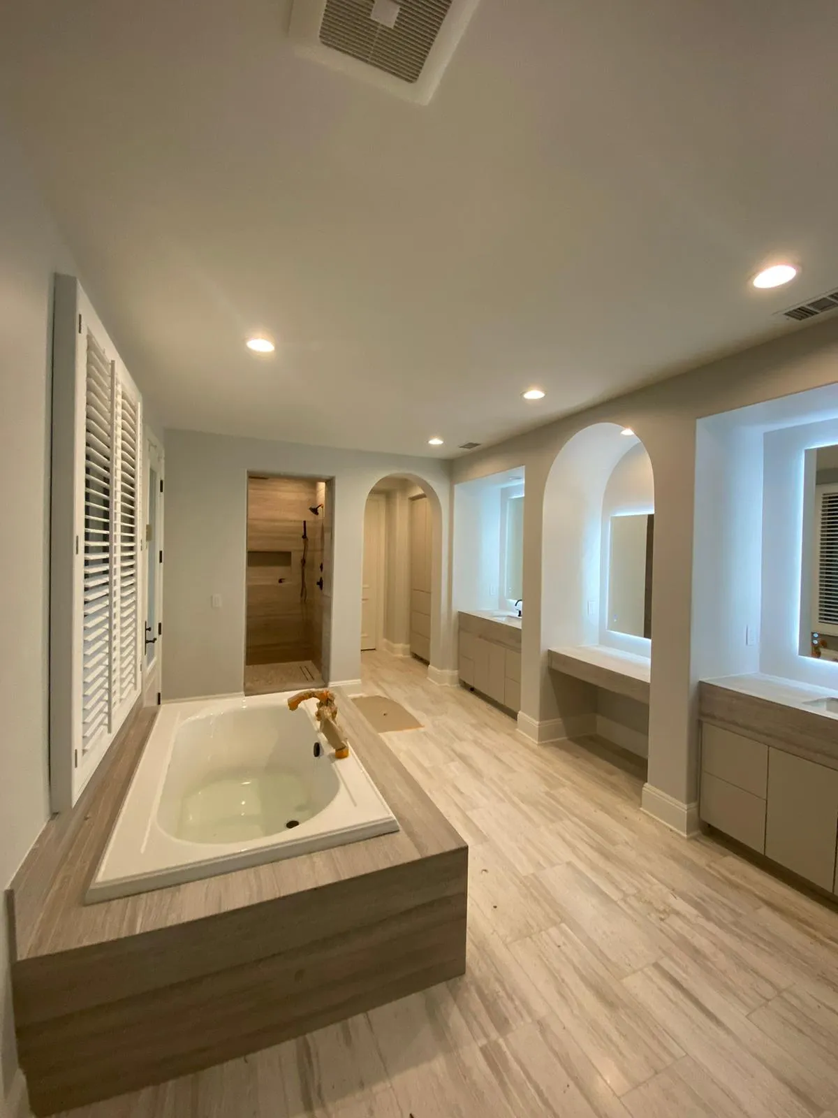 Bathroom with wood-clad soaking tub and brass fixtures