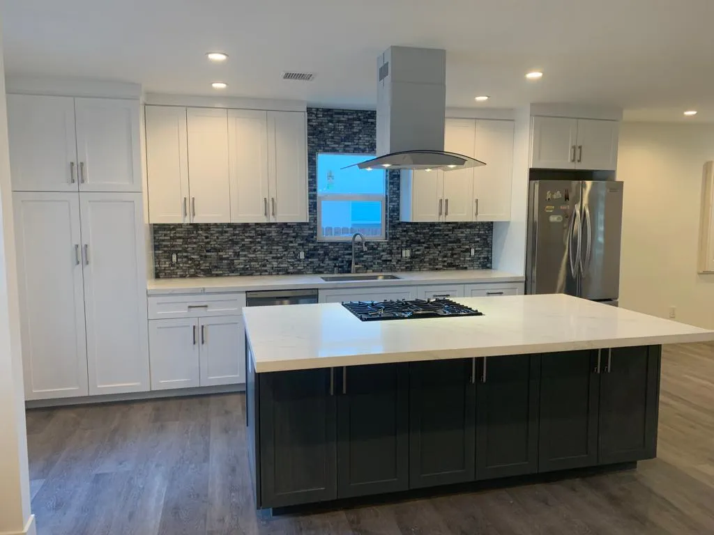 White kitchen with mosaic backsplash and island cooktop