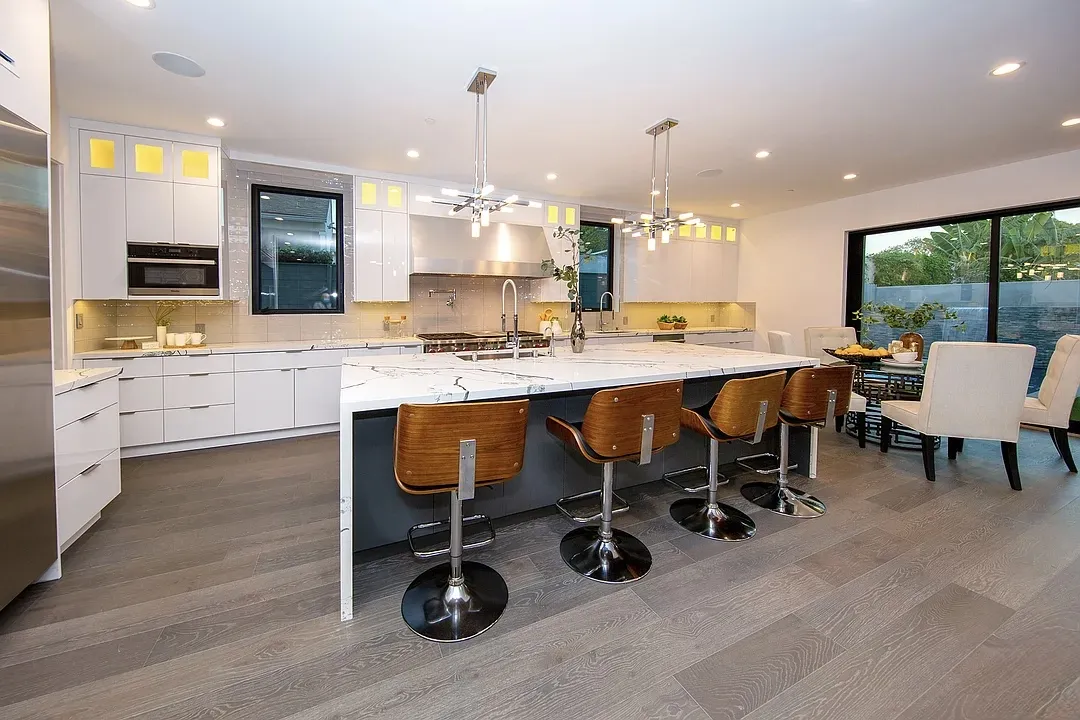 White kitchen with waterfall island and leather bar stools