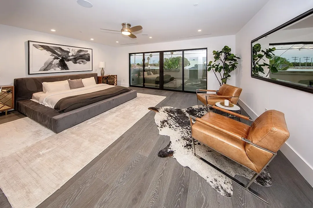 Primary bedroom with leather chairs and wide plank oak floors