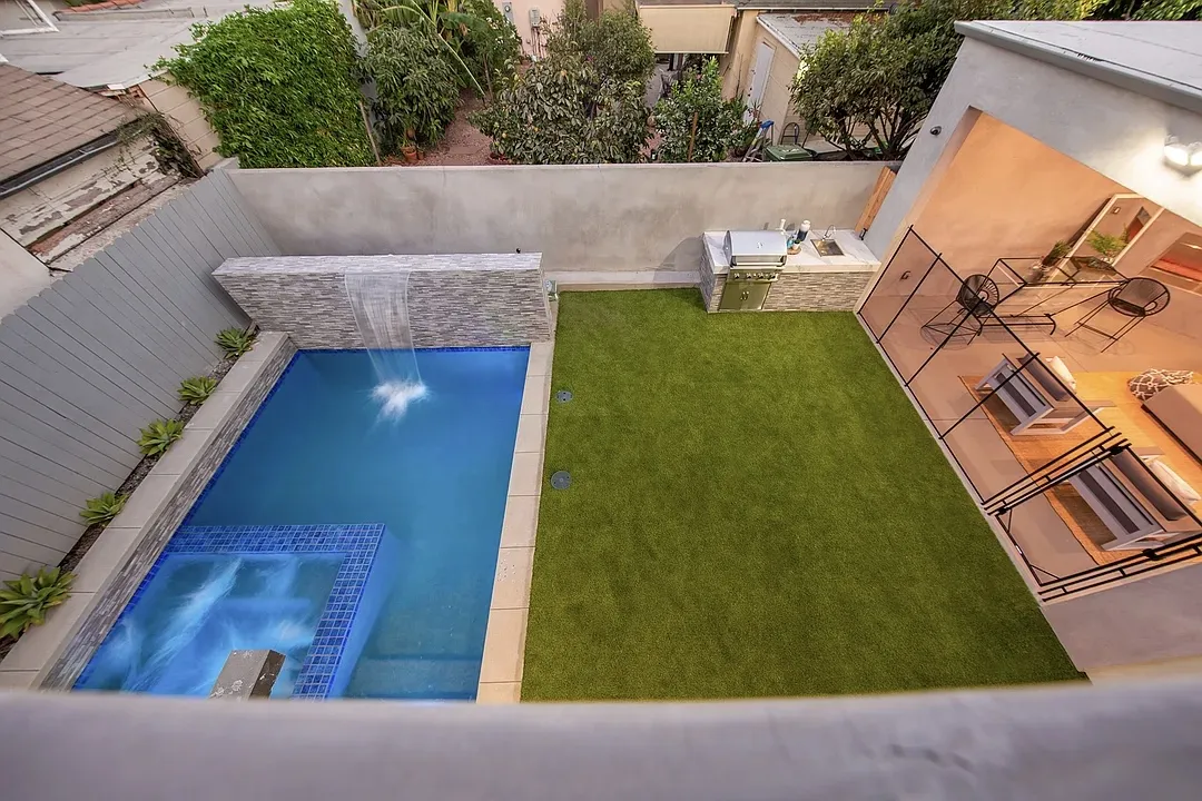 Aerial view of the pool, spa and turf backyard